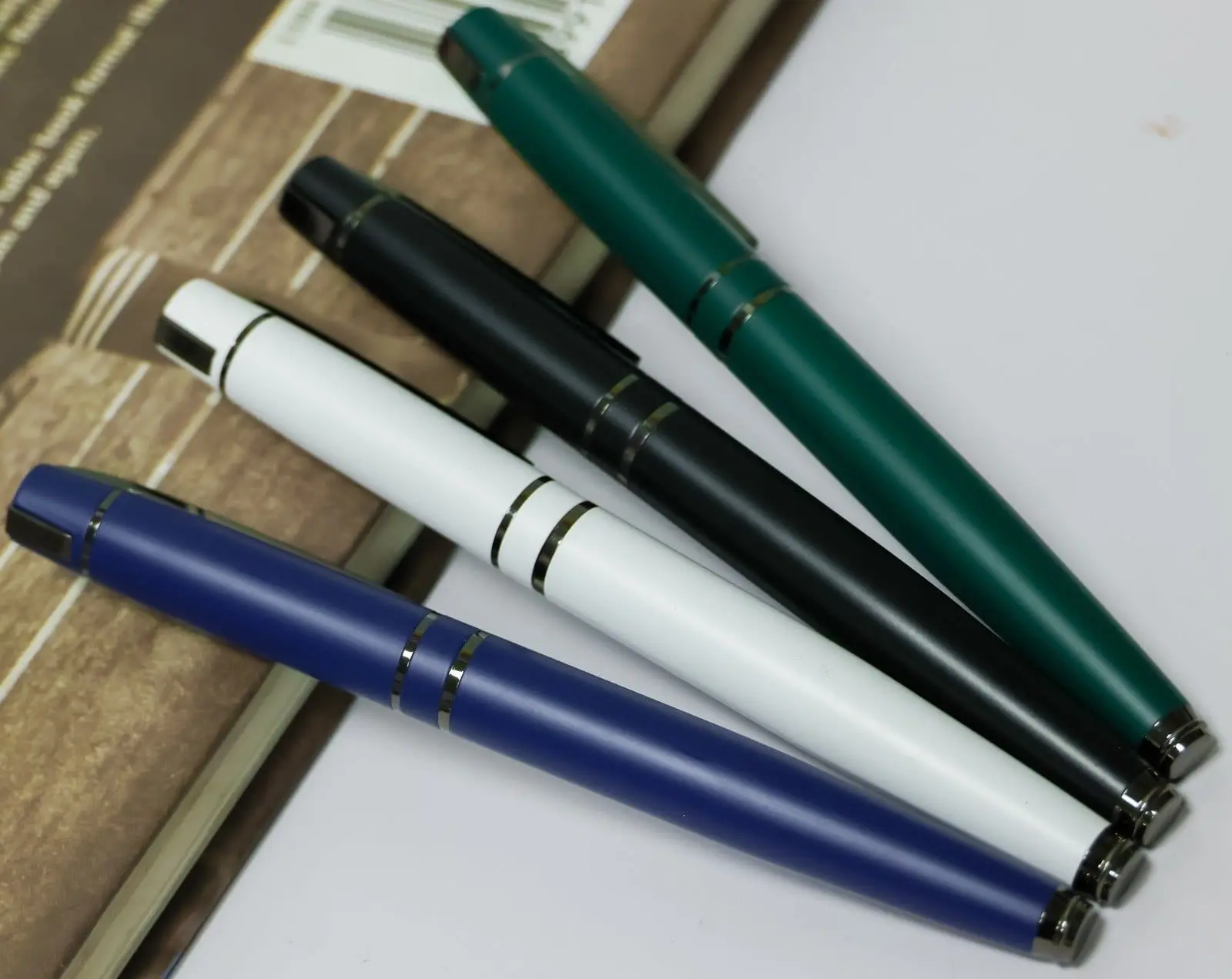 Four matte metal pens in blue, white, black and green with dark double rings, Hensa
