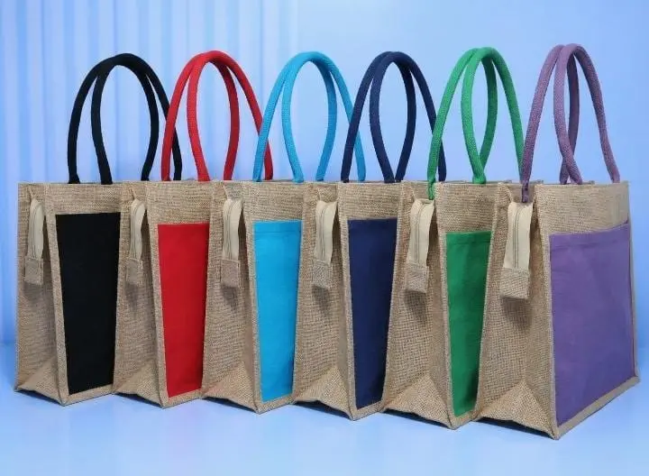 Six jute bags with black, red, cyan, navy, green and purple front pockets and matching handles, Hensa