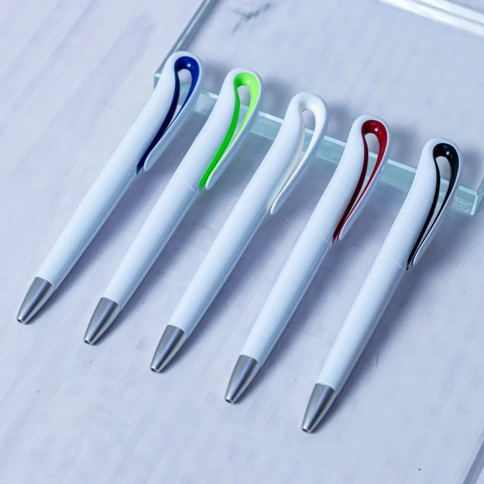 Five white plastic pens with curved clips in blue, lime, white, red and black, Hensa