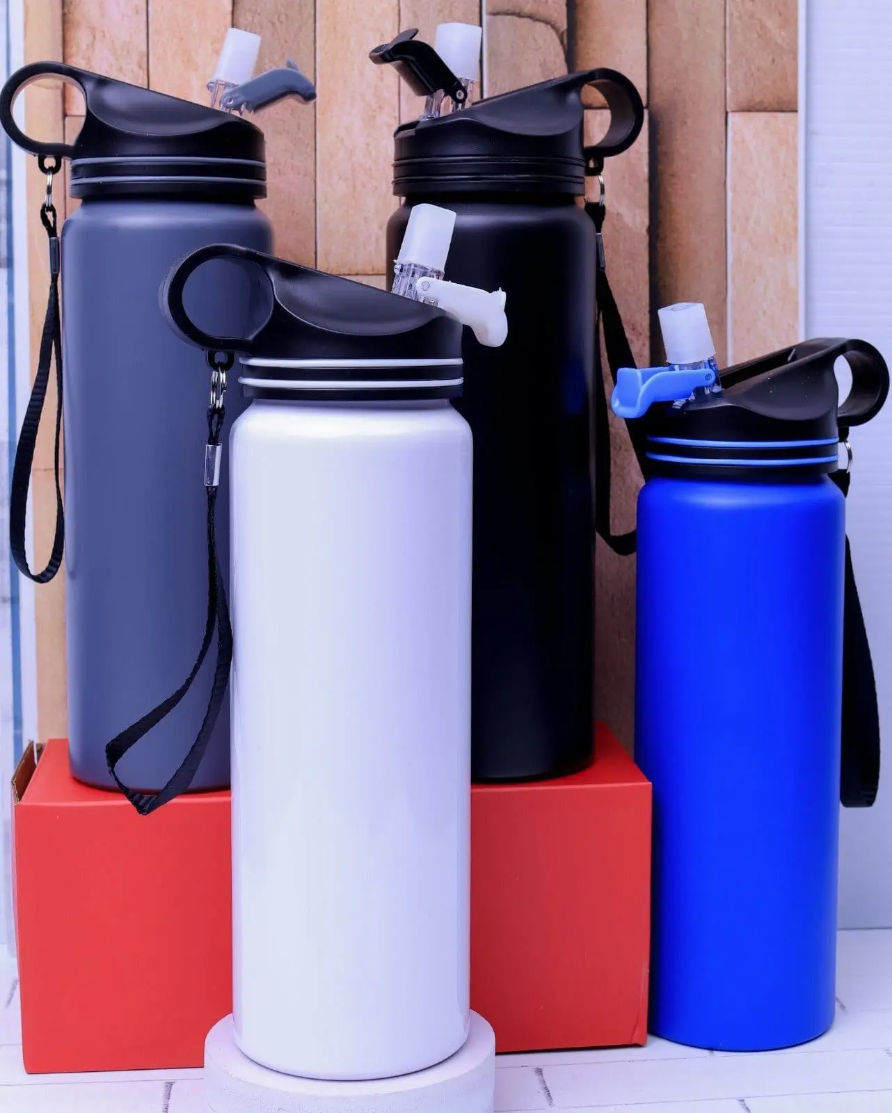 Four metal water bottles with straw lids and lanyards in grey, black, white and blue, Hensa