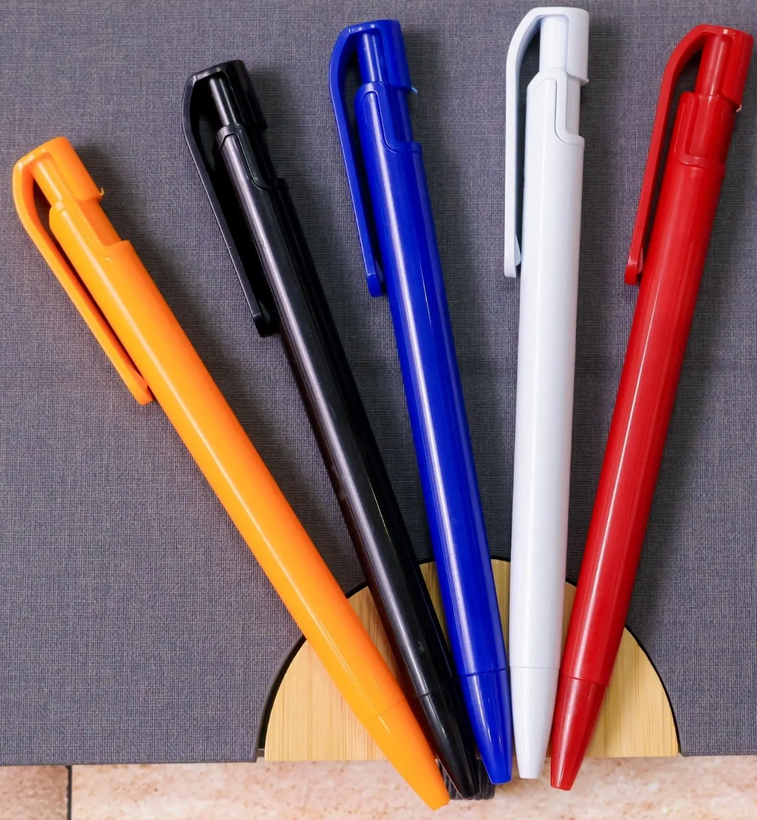 Five plastic click pens in orange, black, blue, white and red, Hensa