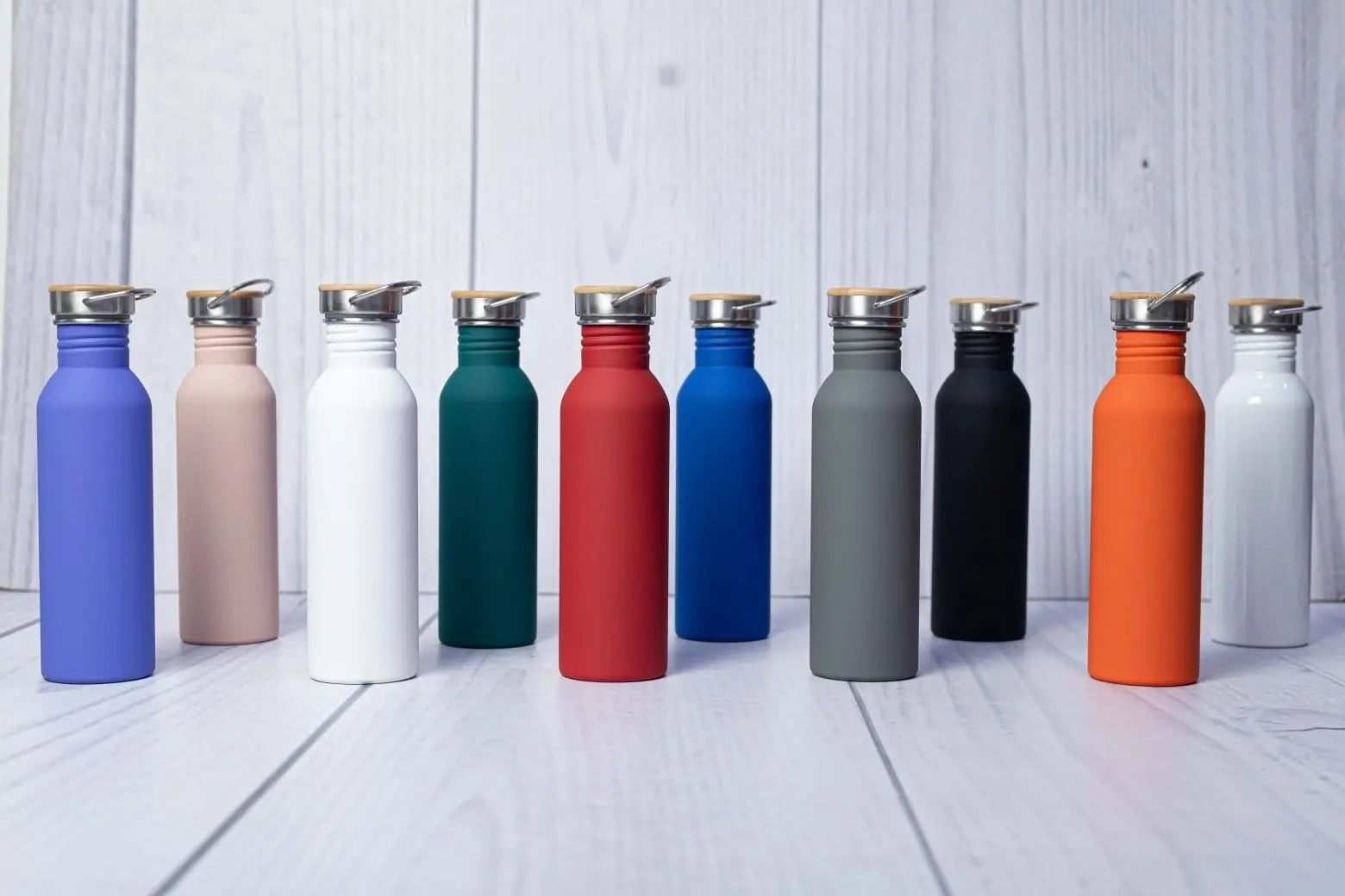 Row of slim matte water bottles with wooden lids in many colours, Hensa