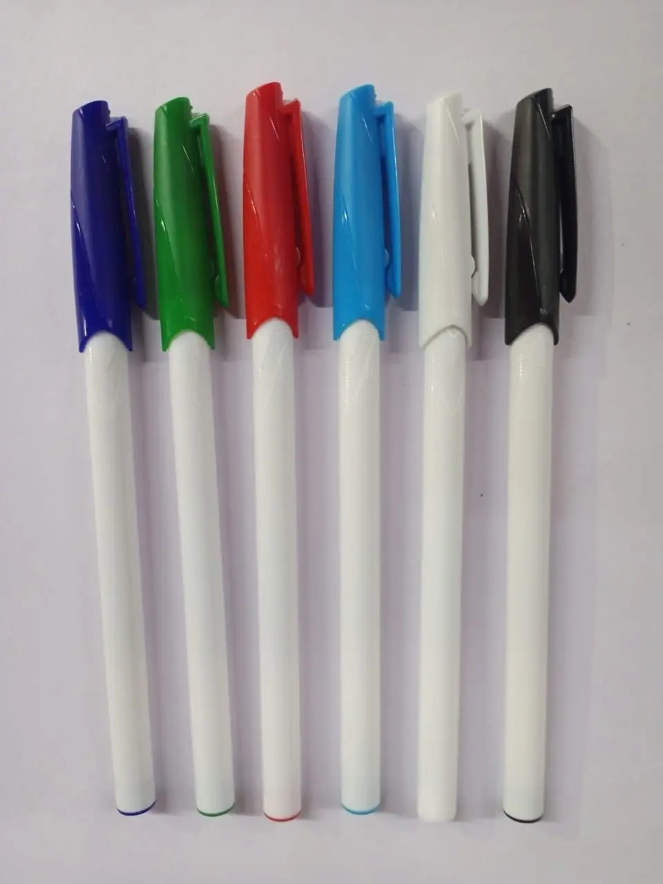 White pens with coloured caps in a row, Hensa