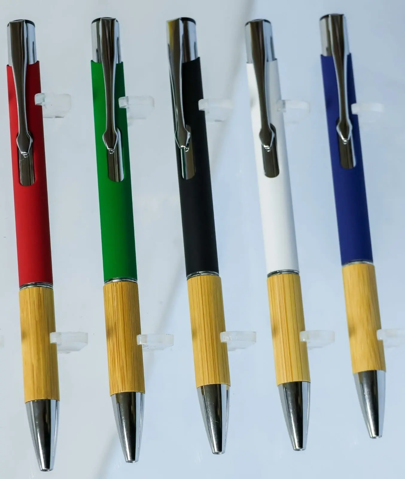 Five click pens in red, green, black, white and blue with wooden grips and chrome clips, Hensa