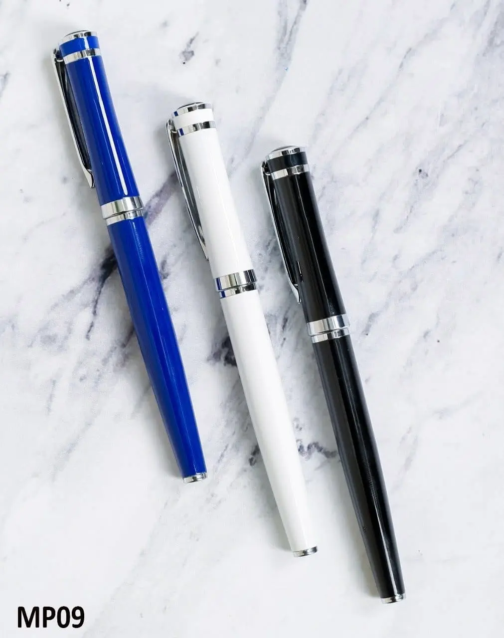 Blue, white and black metal pens with silver clips and rings on a marble surface, Hensa