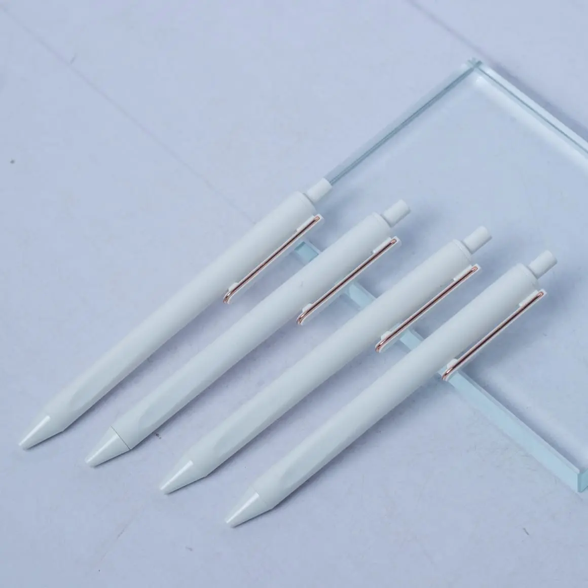 Row of white barrel plastic pens with coloured accents, Hensa