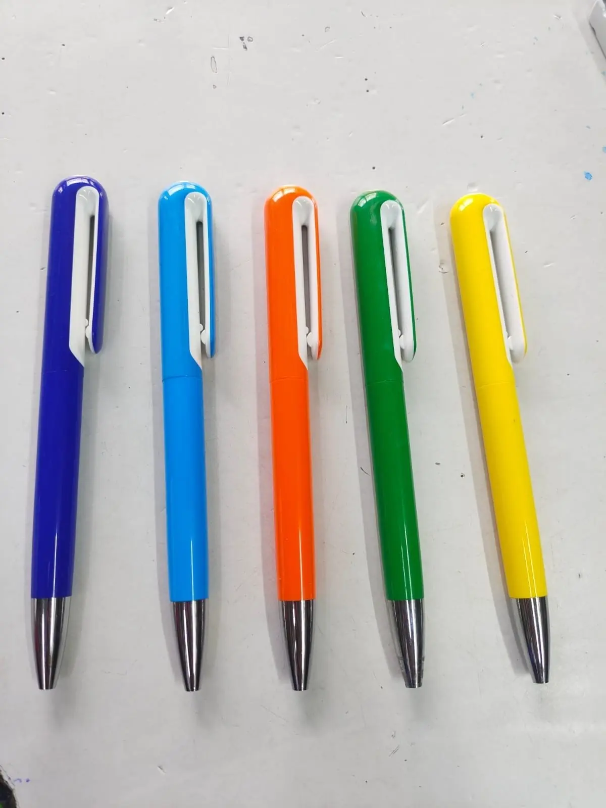 Coloured metal-tip pens with white clips in a row, Hensa
