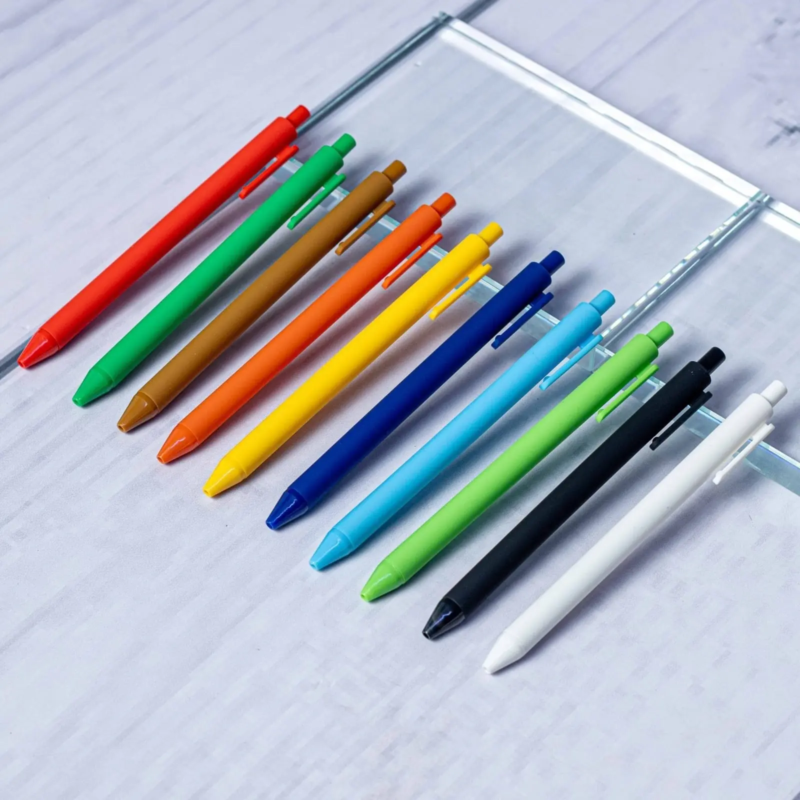 Row of matte plastic pens in red, green, orange, yellow, navy and white, Hensa