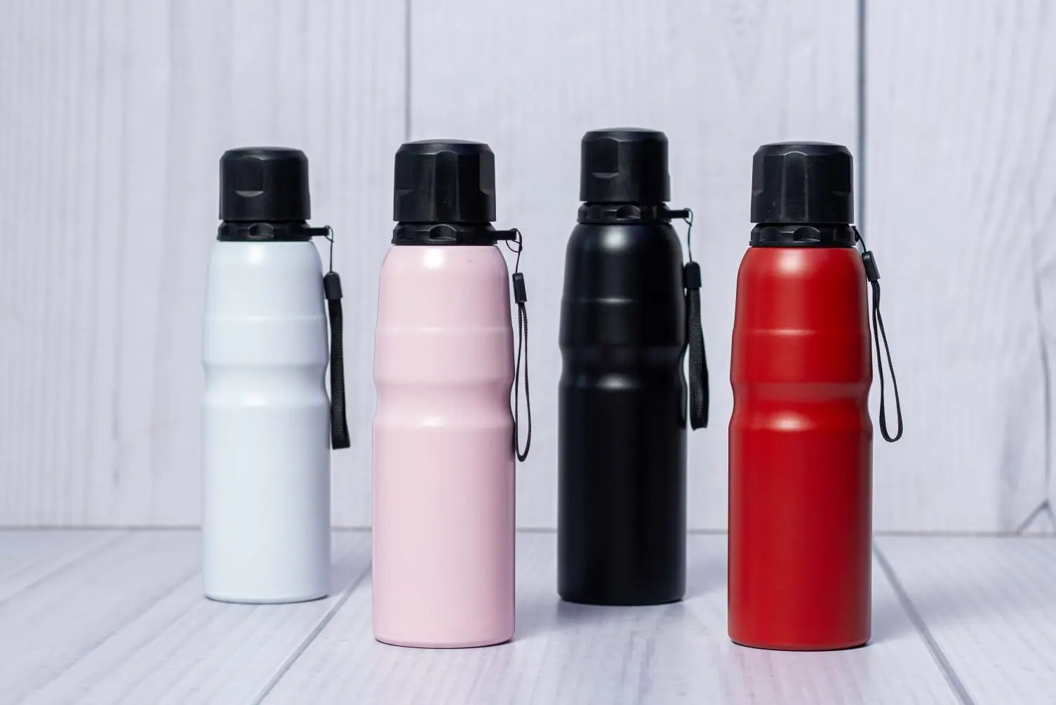 Four contoured sporty water bottles in white, pink, black and red, Hensa