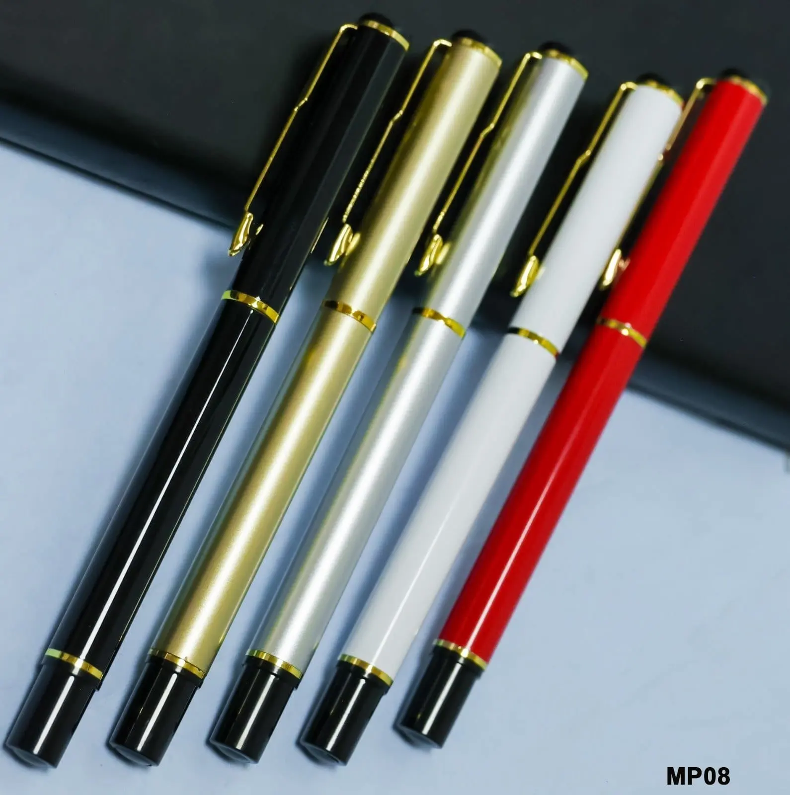 Five metal pens in black, gold, silver, white and red with gold clips and gold bands, Hensa