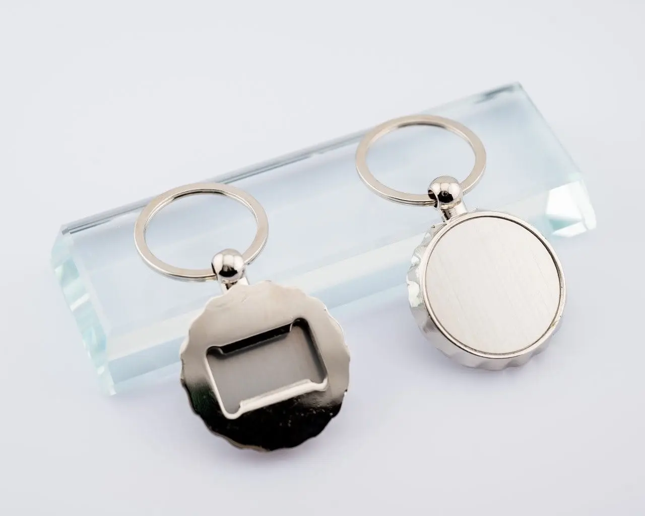 Two round silver bottle opener keyholders, Hensa