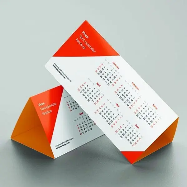 Orange and white table tent calendars standing on a desk showing months, Hensa